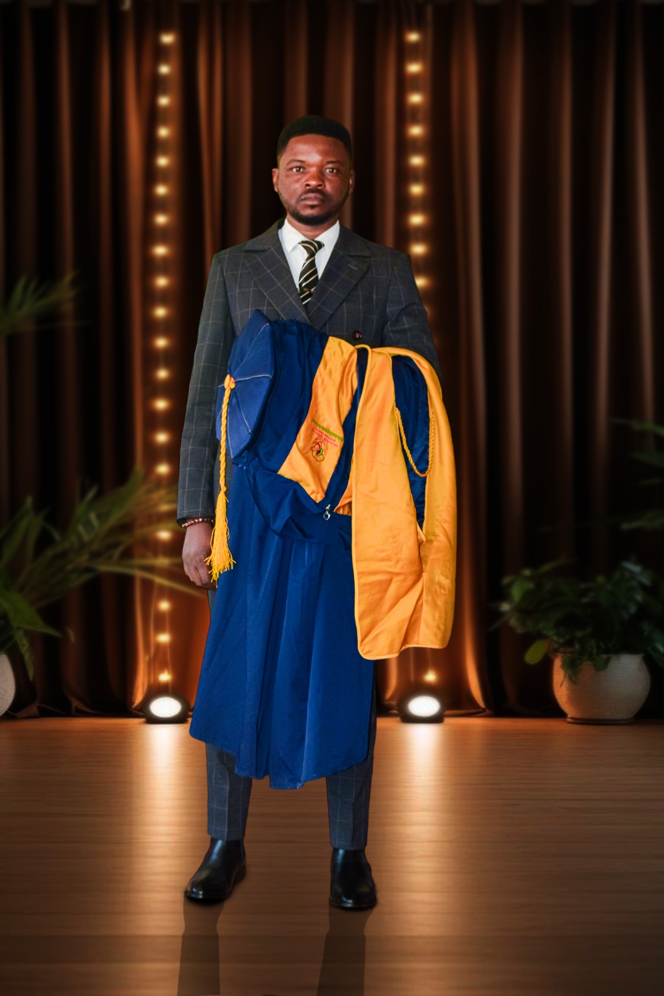 Abanda Emmanuel C. holding his graduation gown